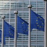 An image of EU flags outside of the EU Parliament